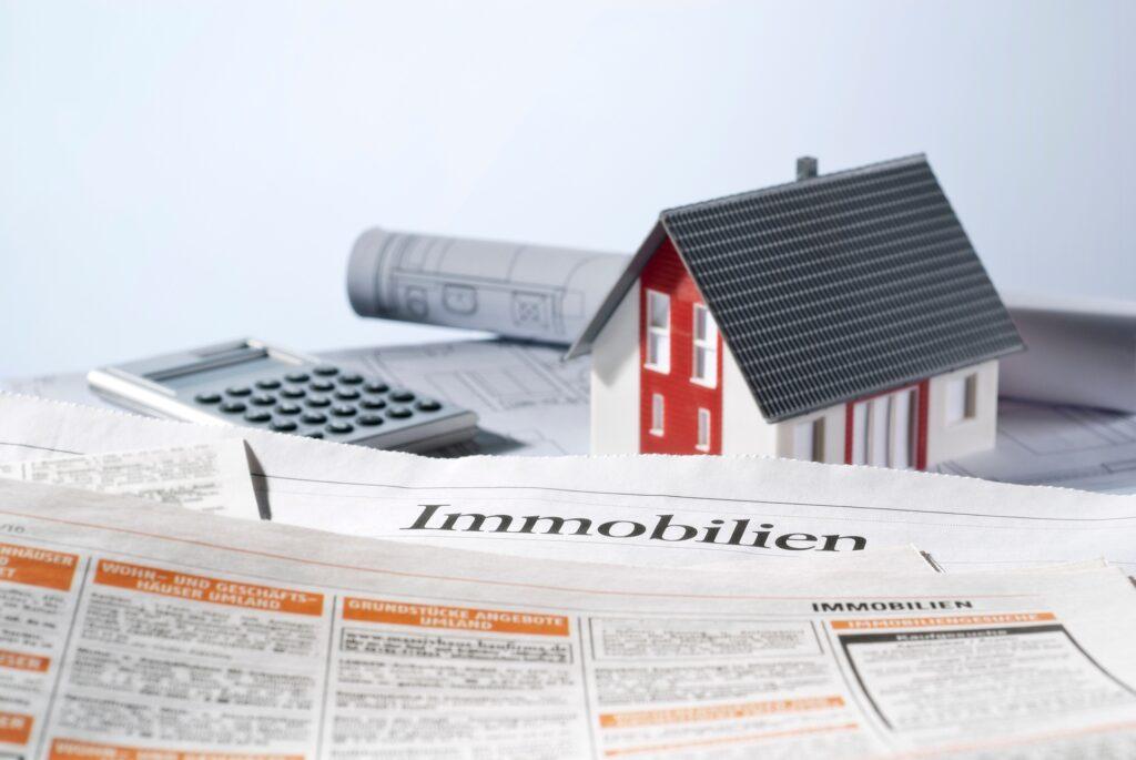 Immobilienanzeige mit Hausmodell und Bauplänen | Photovoltaik Halle