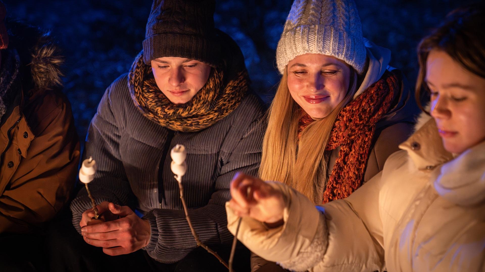 Freunde grillen Marshmallows am Lagerfeuer beim Wintercamping | Petroleum Heizung Camping