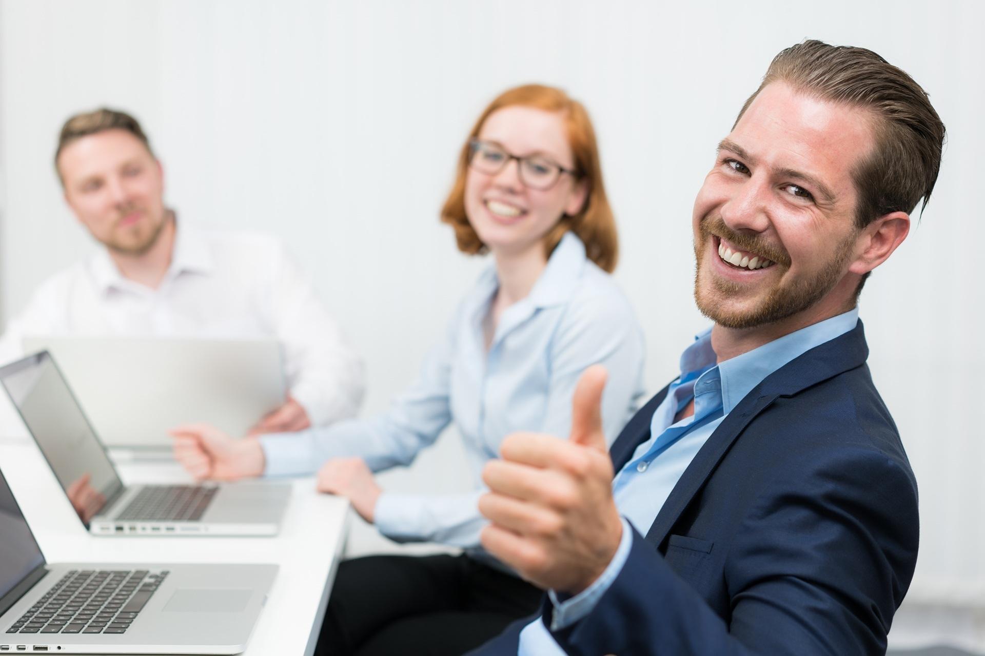 Mitarbeiter zeigt Daumen hoch im Meeting | Bachelorarbeiten schreiben lassen