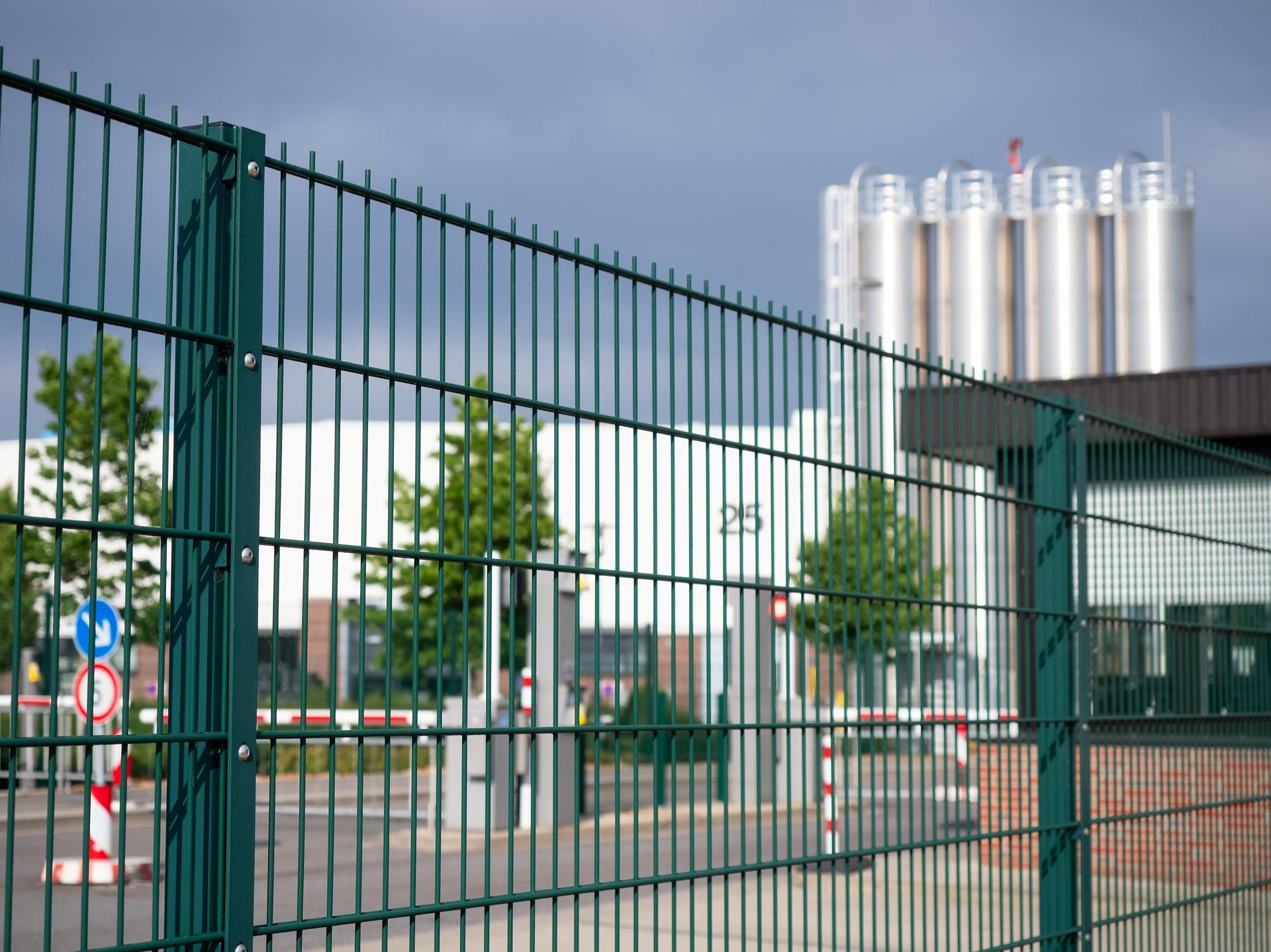 Stahlzaun vor Industrieareal mit Fabrikgebäuden | Schiebetor Freiburg