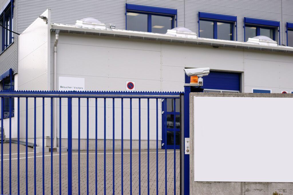 Blaue Toranlage mit montierter Überwachungskamera | Schiebetor Freiburg
