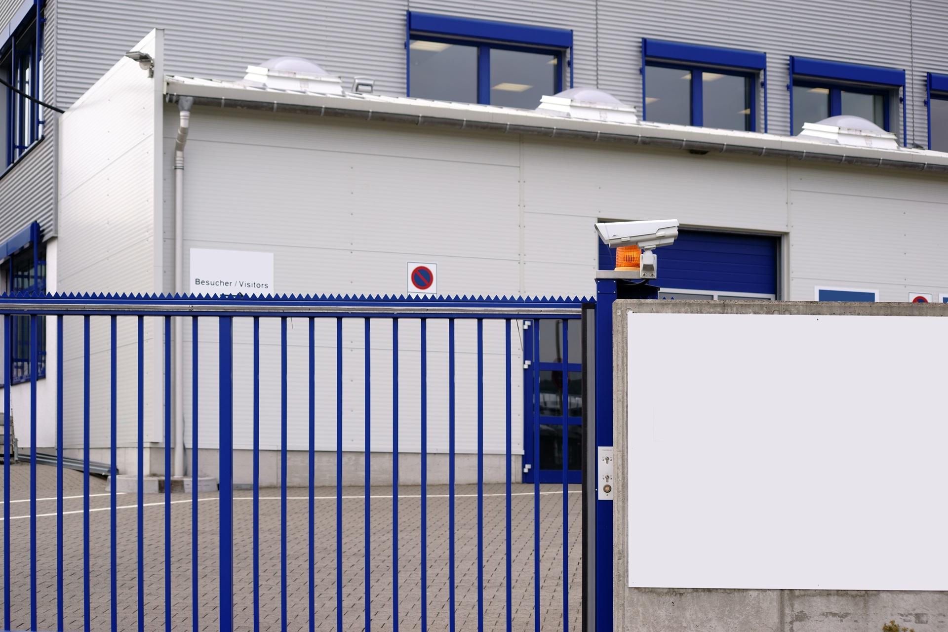 Blaue Toranlage mit montierter Überwachungskamera | Schiebetor Freiburg
